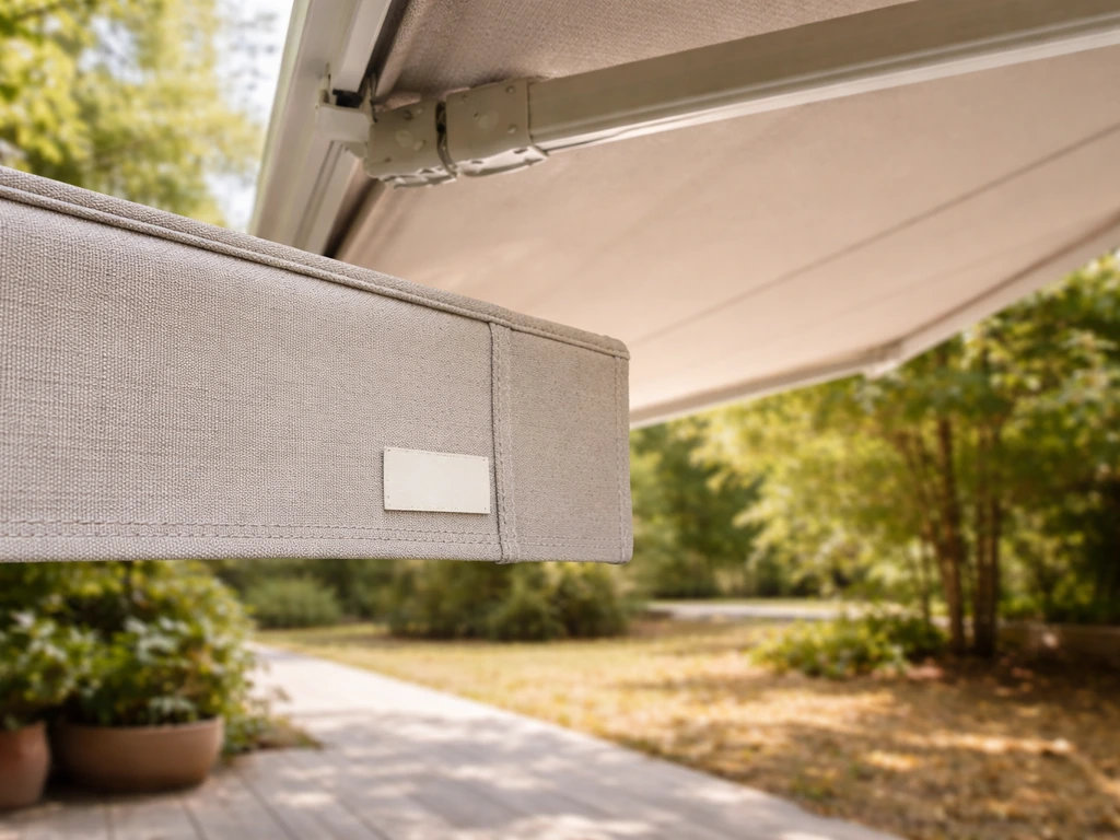 Outdoor awning fabric showing a small certification tag beside it, with light breeze vs high-wind tension implied.