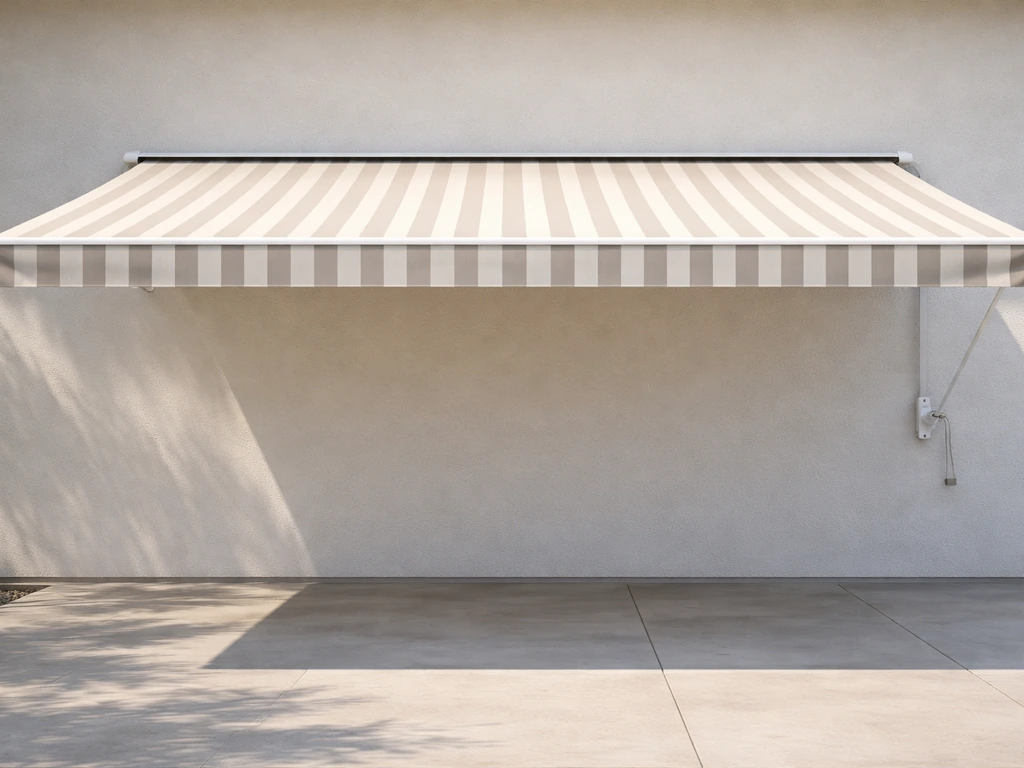 Manual retractable patio awning extended over a patio with the crank end visible.
