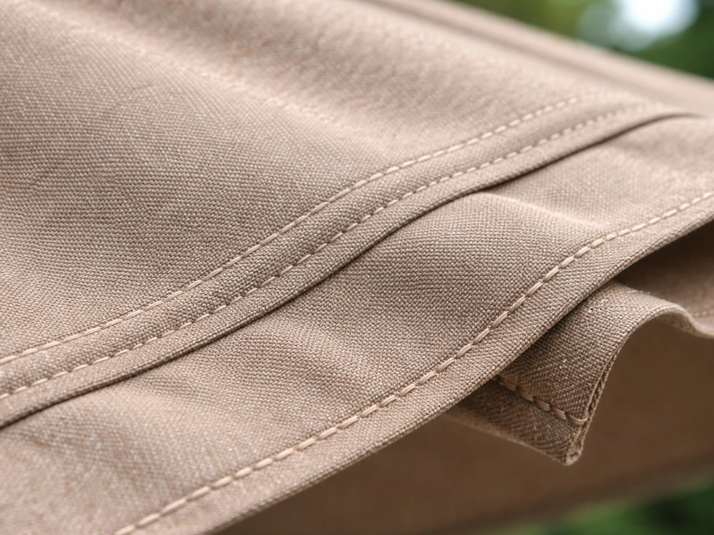 Close-up of solution-dyed acrylic outdoor awning fabric texture with visible weave, UV/fade cues, and stitched seams.