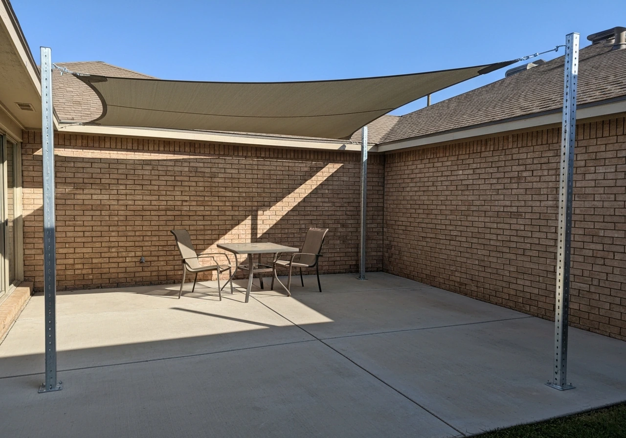 Patio shade cloth sail stretched between posts, covering seating area with soft shadows